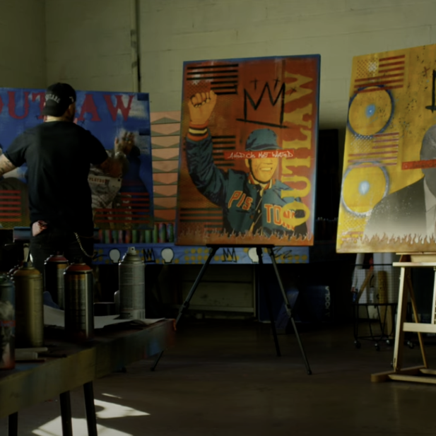 Travis Austin painting Outlaw canvases in art studio - Outlaws Never Die Travis Austin wearable art